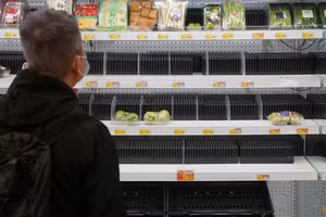 Khách hàng đứng trước giá để hàng ở siêu thị trống rỗng tại Hong Kong.