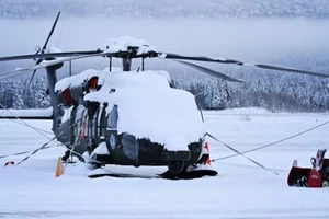 Lực lượng Vệ binh Quốc gia của Quân đội Alaska (Mỹ) dọn tuyết xung quanh trực thăng UH-60 Black Hawk tại Căn cứ Liên hợp Elmendorf-Richardson.