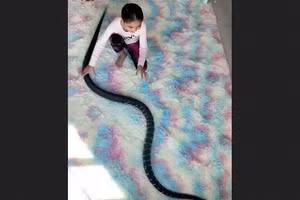 Hình ảnh từ video cho thấy một bé gái chơi đùa với rắn.