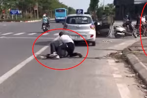 Anh Nguyễn Trần Minh vật lộn với tên cướp, trong khi người mặc quần xanh đứng bấm điện thoại. Ảnh cắt từ Clip