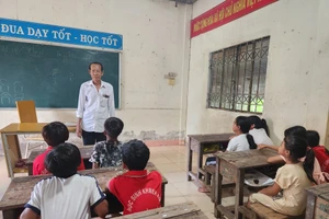 Ông Danh Nghe dạy học cho các em học sinh