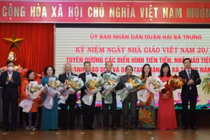 Bí thư quận ủy Hai Bà Trưng Nguyễn Văn Nam và Phó Vụ trưởng Vụ Giáo dục Trung học Đỗ Đức Quế tặng hoa chúc mừng các nhà giáo