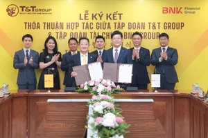 Ông Đỗ Quang Hiển, Chủ tịch UBCL Tập đoàn T&T Group (bên trái) và ông Bin Dae-in, Chủ tịch HĐQT kiêm TGĐ Tập đoàn Tài chính BNK (bên phải) trao thỏa thuận hợp tác với sự chứng kiến của đại diện lãnh đạo hai Tập đoàn.