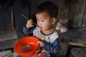 Bữa sáng cơm trộn nước sôi trong góc bếp nghèo nàn