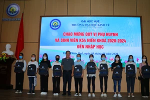 Đại diện lãnh đạo Trường ĐHKT Huế tặng tân sinh viên đến nhập học chiếc ba lô kỷ niệm ngày đầu tiên bước vào ngôi trường mới