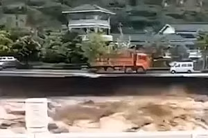 Chiếc xe tải đỏ trước khi rơi xuống dòng lũ dữ