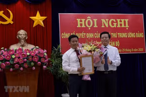 Ông Mai Văn Chính, Ủy viên Trung ương Đảng, Phó trưởng Ban Tổ chức Trung ương trao Quyết định của ban Bí thư cho ông Lê Quân. (Ảnh: Kim Há/TTXVN)