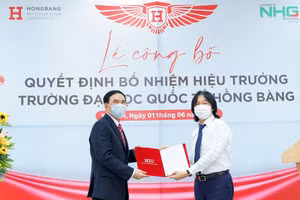 Ông Hoàng Quốc Việt - Chủ tịch Tập đoàn Nguyễn Hoàng trao quyết định, tặng hoa chức mừng cho Hiệu trưởng GS.TS Phạm Văn Lình (bên phải)