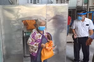 Một người già vào nhận gạo tại "ATM gạo" của thầy giáo về hưu cùng những người bạn