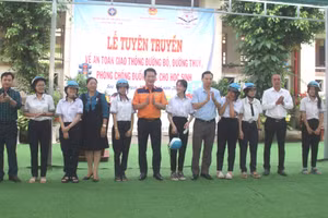 Trao tặng mũ bảo hiểm bảo đảm chất lượng cho các em HS.