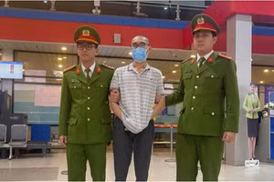 Lực lượng chức năng dẫn giải đối tượng Hoàng Minh Toàn từ TP. Hồ Chí Minh về Quảng Bình. Ảnh: CAQB.