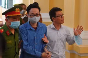 Bị cáo Nguyễn Hải Nam và Lâm Hoàng Tùng được hộ tống ra xe, sau khi phiên tòa bị hoãn. Ảnh: CTV