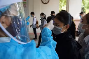 Học sinh Trường THPT Trần Quốc Tuấn, TP Quảng Ngãi đo thân nhiệt trước khi làm thủ tục dự thi tốt nghiệp THPT hồi tháng 8. 