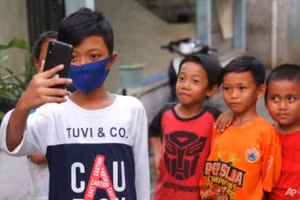 Học sinh lớp 5 của Trường Tiểu học Qayran Ruby Al Maghribi kiểm tra chiếc điện thoại di động do Ghina Ghaliya gửi tới.