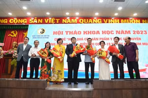 Các đại biểu tặng hoa chúc mừng các nhà nghiên cứu ứng dụng thuốc y học cổ truyền vào thực tế.