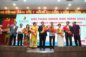 Các đại biểu tặng hoa chúc mừng các nhà nghiên cứu ứng dụng thuốc y học cổ truyền vào thực tế.