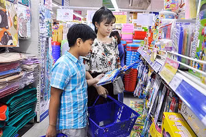 Phụ huynh dẫn con đi mua đồ dùng học tập .