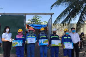 Ông Hậu cùng đại diện Hội Liên hiệp Phụ nữ Đà Nẵng tặng sữa cho công nhân quét rác. 