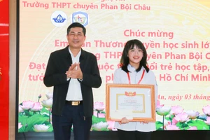 Ông Thái Văn Thành - Giám đốc Sở GD&ĐT Nghệ An chúc mừng em Trần Thương Huyền - học sinh lớp 12C7 Trường THPT chuyên Phan Bội Châu.