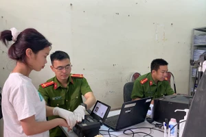 Công an huyện Mai Sơn đang lấy dấu vân tay làm thủ tục cấp CCCD cho học sinh.