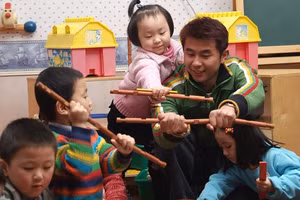 GV mầm non chơi với HS.