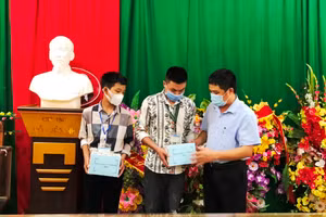 Thầy Trần Anh Văn (phải) - Hiệu trưởng Trường THPT Mường Lát (Thanh Hóa) trao điện thoại do bạn đọc Báo GD&TĐ hỗ trợ cho học sinh nghèo của nhà trường.