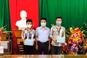 Thầy Trần Anh Văn – Hiệu trưởng Trường THPT Mường Lát trao điện thoại mới cho em Thao Văn Chá (ảnh trái) và em Đinh Công Tú.