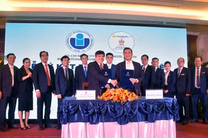 Ông Trần Tiến Khoa - Hiệu trưởng IU (trái) và ông Phan Thanh Long - Giám đốc Rex Hotel trao văn bản ký kết hợp tác. Ảnh: C.Chương.