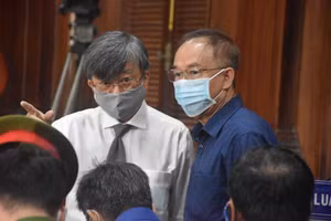 Ông Nguyễn Thành Tài trao đổi đổi với luật sư tại tòa. Ảnh: C.Chương