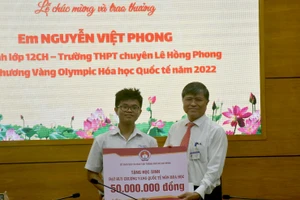  Ông Nguyễn Văn Hiếu - Giám đốc Sở GD&ĐT TPHCM (phải) trao khen thưởng cho em Nguyễn Việt Phong.