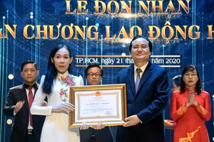 Bộ trưởng Phùng Xuân Nhạ (phải) trao Huân chương Lao động hạng Ba cho PGS.TS Trần Thị Mỹ Diệu - Hiệu trưởng VLU.