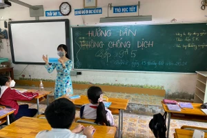 Giáo viên Trường THCS Chánh Hưng (Q.8, TPHCM) hướng dẫn HS về an toàn phòng chống dịch, sáng 13/12.