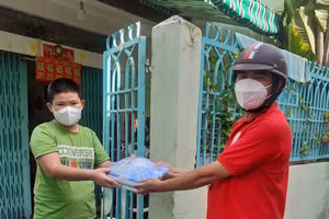 Thầy Phó Trọng Huy (phải) - Hiệu trưởng Trường THCS Tùng Thiện Vương (Q.8, TPHCM) giao SGK cho HS trên địa bàn Q.8, TPHCM.