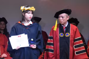 Bùi Ngọc Bích Thảo (trái) nhận tuyên dương từ lãnh đạo SIU tại lễ trao bằng tốt nghiệp (2/4).