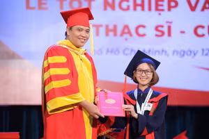 TS Bùi Kim Hiếu (trái) trong một sự kiện trao bằng tốt nghiệp cho SV.