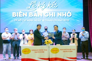 Đại diện HUFLIT và MoMo trao văn bản ký kết.