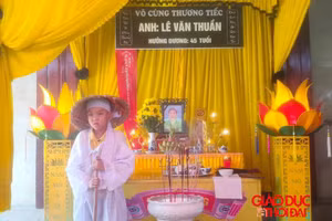 Em Lê Văn Đình Mạnh bên di ảnh bố.