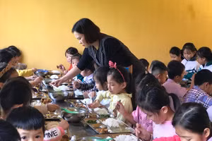 Cô Vũ Thu Hương hỗ trợ học sinh trong bữa ăn bán trú.