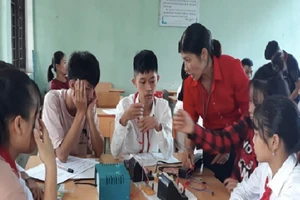 Cô Nguyễn Thị Thuý Cẩm, GV Toán – Lý, Trường Phổ thông dân tộc bán trú THCS Đồn Đạc sinh hoạt nhóm công nghệ cùng học sinh.