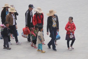 Những em nhỏ dắt díu nhau, lang thang theo du khách bán hàng ở trung tâm thị xã Sa Pa.
