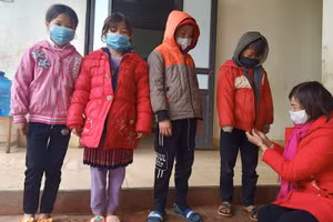 Cô Hoàng Thị Oánh tận tay mặc áo ấm cho học sinh.