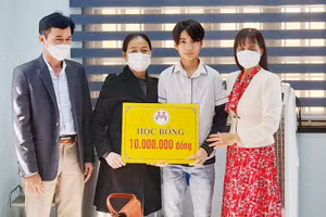 Cô Lan (áo đen) trao học bổng cho em Nguyễn Trọng Tấn – học sinh lớp 8, Trường THCS Trần Hưng Đạo (thành phố Đông Hà) trong những ngày đầu năm mới Nhâm Dần 2022.