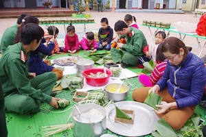 Chiến sĩ và giáo viên Trường Mầm non Núa Ngam (Điện Biên) gói bánh chưng tặng học sinh và hộ nghèo trên địa bàn.