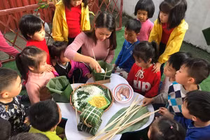 Giáo viên Trường Mầm non Bình Minh (TP Bắc Giang) gói bánh chưng Tết và giới thiệu văn hóa Tết Việt cho học sinh. Ảnh: NTCC