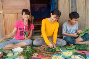 Cô Trà Thị Thu cùng phụ huynh gói bánh chưng chuẩn bị đón Tết từ nguồn hỗ trợ của các nhà hảo tâm. 