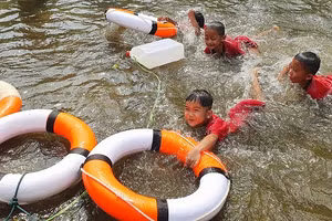 Trẻ được thực hành kỹ năng cứu đuối bằng cách ném phao, can nhựa cho người gặp nạn.