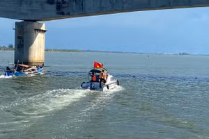 Lực lượng chức năng sử dụng phương tiện ca nô tuần tra, tìm kiếm dưới chân cầu Cửa Việt (Ảnh: Minh Cường).