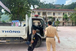 Em Lo Thiên Long vội vàng chạy vào phòng thi, tay vẫn cầm cả mũ bảo hiểm. Ảnh: CA Kỳ Sơn