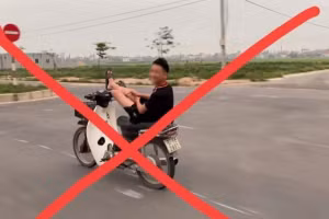 Hình ảnh nam thanh niên dùng 2 chân lái xe máy.