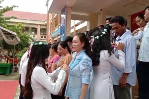 Các em học sinh lớp 12 cài hoa tri ân cha mẹ.